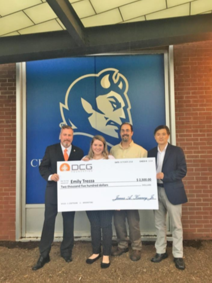 Emily Trezza accepts a $2,500 check from the Diversity Construction Group (DCG). From left to right: DCG President James A Keaney, Emily Trezza, Trezzas father Michael Trezza and CCSU Construction Management Professor Dr. Namhum Lee.