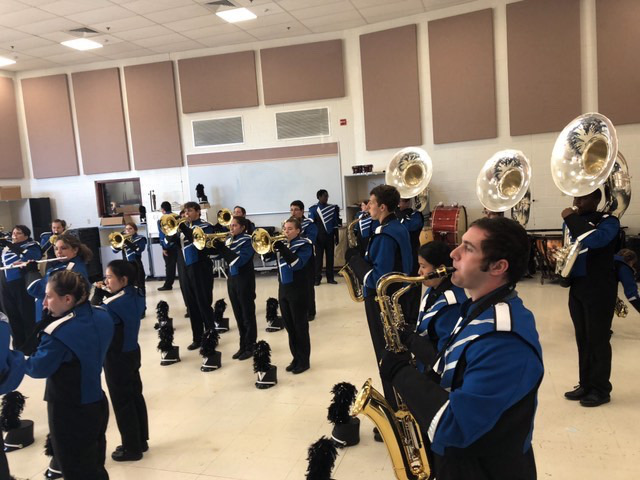 Before their exhibition, the Blue Devils Marching Band warms up in a practice room before their performance. 