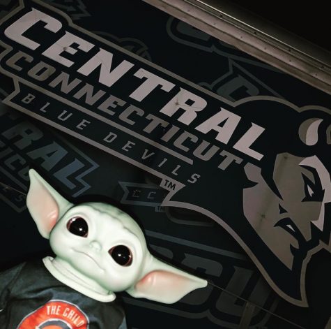 Baby Yoda poses in front of the CCSU logo.