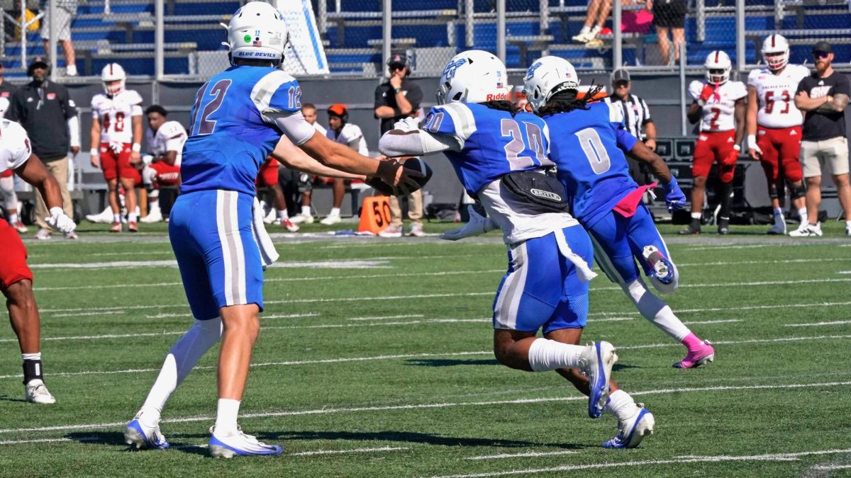 CCSU quarterback Brady Olson (12) hands the ball off to running back Donny Marcus (20) during Saturday's overtime win against Sacred Heart