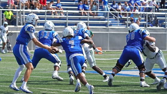 CCSU quarterback Brady Olson (12) hands the ball off to running back Elijah Howard (7) during Saturday’s game against Dartmouth.